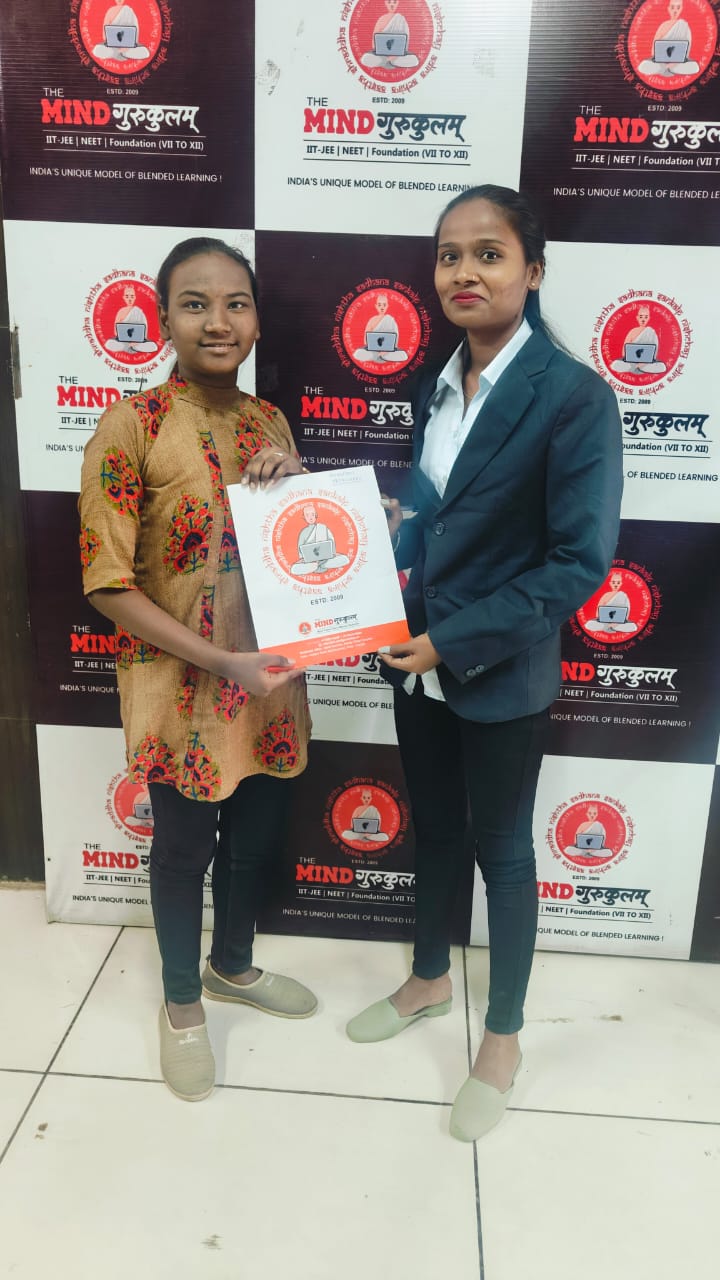 Student receiving programme information at the Mind Gurukulam backdrop